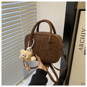 Detailed view of leopard print crossbody bag with cute teddy bear charm and soft finish