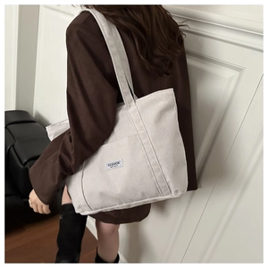 Detailed texture of off-white corduroy tote bag with Fashion Instinct label and front pocket