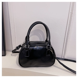 Dettaglio borsa bowling in pelle nera lucida con finiture argento e tracolla regolabile