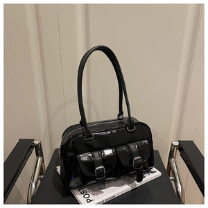 Detail of black patent leather shoulder bag with glossy finish and double front buckle pockets
