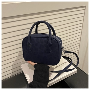 Gros plan du sac bandoulière bleu foncé à motif léopard avec texture mate chic