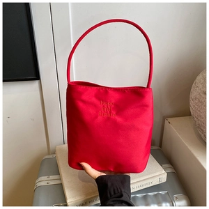 Close-up of red nylon bucket bag featuring detailed Hope and Future embroidery on surface
