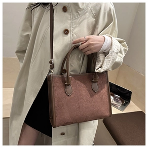 Détail du sac cabas marron vintage avec texture trèfle embossée et bandoulière en cuir
