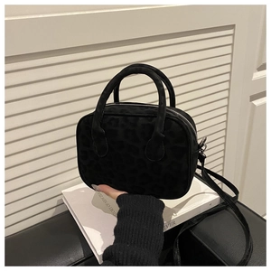 Détail du mini sac baguette noir avec motif léopard subtil et finitions argentées