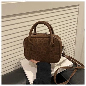 Détail d'un sac bandoulière en daim léopard marron avec doubles anses et sangle