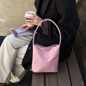 Pink nylon bucket bag with Hope and future embroidery in a casual lifestyle setting