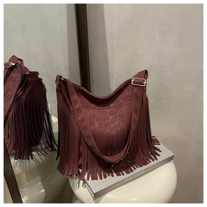 Dettaglio borsa tote bordeaux con nappe, motivo leopardato e finiture in metallo dorato
