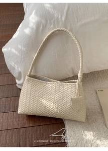 Détail du sac tressé crème avec poignée nouée sur fond de décoration intérieure