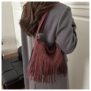Detail of burgundy fringe hobo bag in suede texture with metallic ring buckle