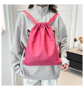 Detail of bright pink nylon drawstring bag with shiny fabric and wide shoulder straps