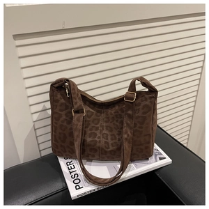 Detailed view of leopard print tote bag featuring soft fabric and gold metal buckles