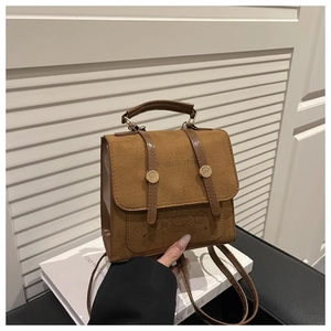 Detail of brown suede backpack with golden rivets and cartoon embossed patterns