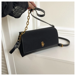 Détail du sac carré en cuir noir brillant avec fermoir doré et bandoulière en chaîne