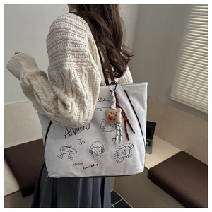 Détails du sac cabas en toile blanche avec imprimés cartoon et anses en cuir