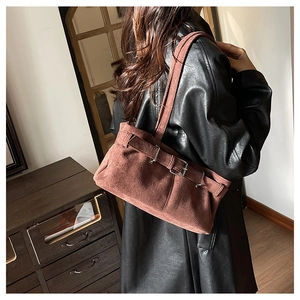 Détail du sac à bandoulière vintage marron foncé avec boucle en métal et texture mate