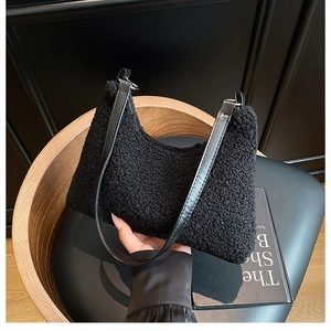 Close-up of black fuzzy lamb wool tote bag with premium leather shoulder strap detail
