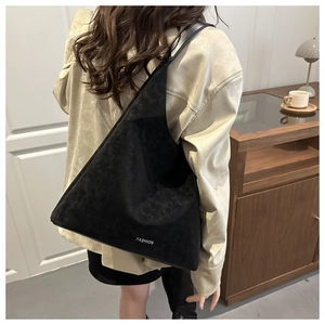 Dettaglio della borsa hobo in pelle scamosciata nera con scritte fashion e design a triangolo