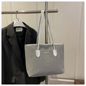Detail view of leopard print fabric tote bag with white FASHION logo and silver straps