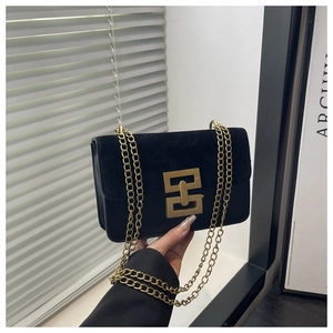 Detailaufnahme der schwarzen Umhängetasche mit goldener Schnalle und Kettengliedern