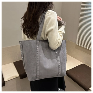 Détail du grand sac cabas en daim gris orné de rivets métalliques argentés élégants
