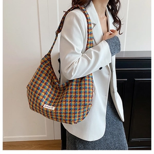Detail of colorful houndstooth crossbody tote with a white power off logo patch