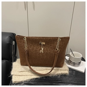 Dettaglio borsa shopper leopardata con catena dorata e ciondolo a cervo in stile chic