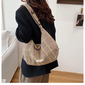 Detail of a large houndstooth fabric tote bag with a power off label on soft fabric