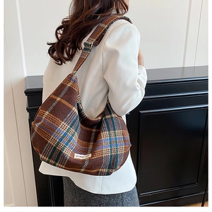 Detail of vintage brown plaid hobo bag featuring a woven texture and adjustable strap