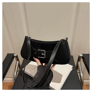 Detail of black leather underarm bag featuring a large silver metal buckle and strap