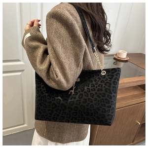 Dettaglio borsa tote leopardata con ciondolo a cervo dorato e tracolla a catena