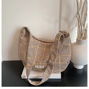 Detail of checkered shoulder bag with power off patch on neutral minimalist background