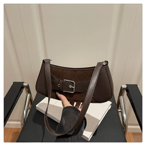 Detail of dark brown leather underarm bag with suede patchwork and silver buckle