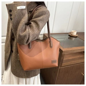 Lifestyle shot of large caramel brown pebbled leather tote bag for women's daily commute
