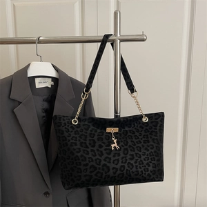 Chic leopard print tote bag with gold chain strap and deer pendant in a stylish setting