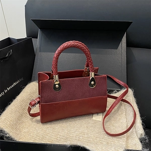 Chic red mixed-media crossbody bag with braided handle and gold-tone hardware