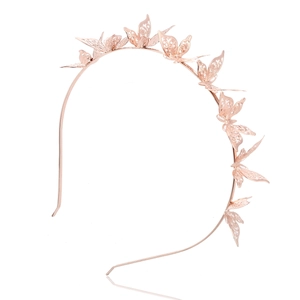 Serre-tête papillon en or rose avec motif en métal ajouré sur fond blanc épuré