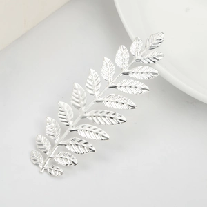 Elegant silver leaf branch hair accessory with polished finish on a clean white surface