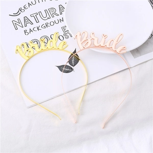 Elegant gold and rose gold Bride To Be tiaras with heart detail on a white plush background