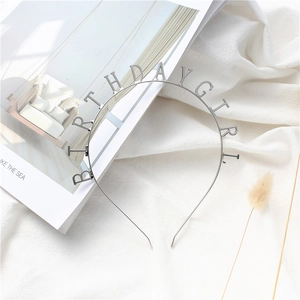 Detail shot of silver Birthday Girl metal headband on a minimalist aesthetic background