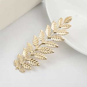 Elegant baroque golden leaf hair pin with detailed metallic texture on white background