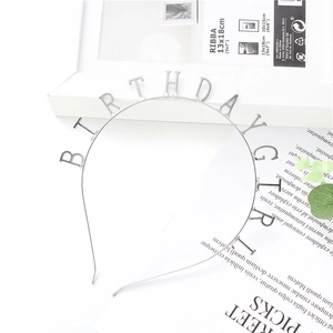 Silver Birthday Girl headband on a white background with decorative lifestyle props