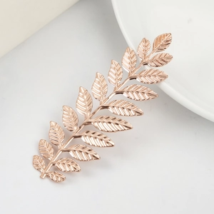 Elegant rose gold metal leaf hair accessory with detailed texture on white background