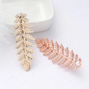 Barrettes à cheveux feuille avec perles en tons or et or rose sur fond blanc élégant