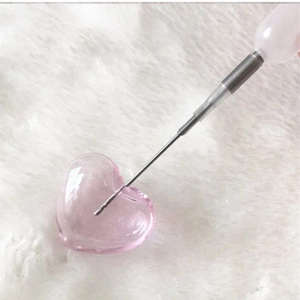 Macro shot of injecting fragrance into a pink translucent heart glass pendant