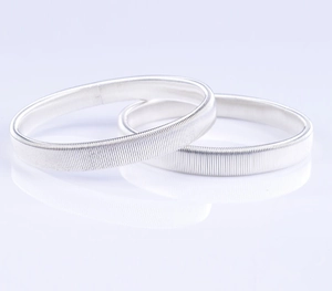 Close-up of a pair of elastic silver metal sleeve garters with spring-like metal texture