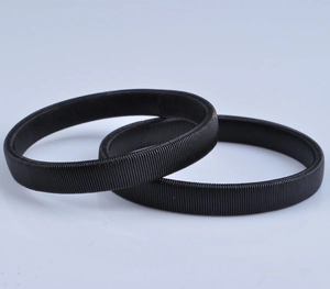 Detail of two black metal spring sleeve garters for men on a neutral grey background
