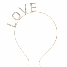 Detailed macro of gold metal headband with rhinestone LOVE design for wedding party