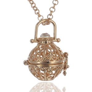 Detail of golden hollow sphere essential oil diffuser pendant with floral filigree patterns