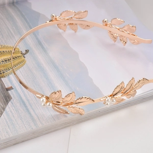 Elegant golden leaf headband with white pearls on a magazine, bridal baroque hair accessory
