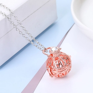Macro shot of rose gold hollow flower pendant with sparkling crystal on silver chain